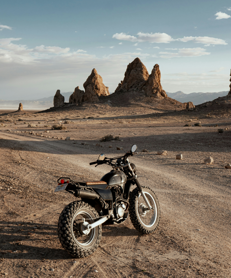 Motorcycle parked in a barren, rocky landscape under a clear sky