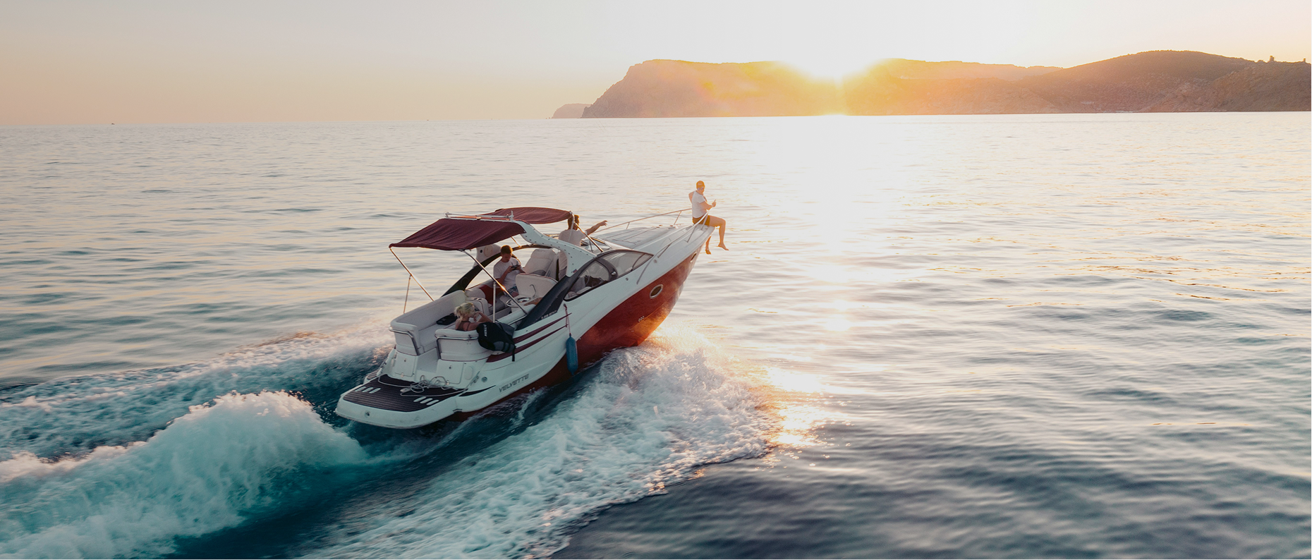 Boat sailing on the open ocean with gentle waves and a bright sky