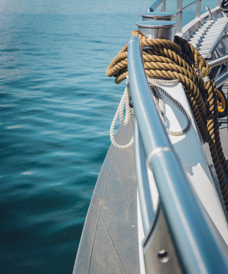 Side view of a sleek boat cruising on calm water under clear skies
