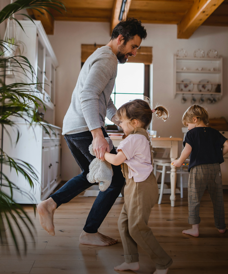 Father playing and having fun with his sons inside their home
