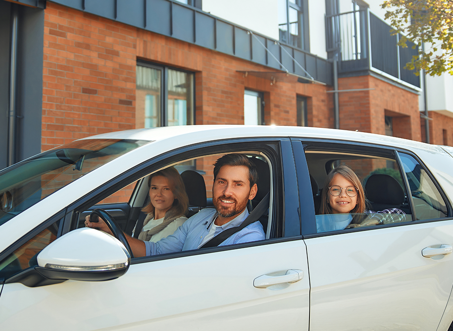 Smiling family sitting together inside a car enjoying a road trip