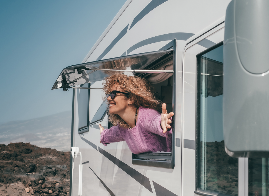 Young girl smiling and looking out the window of a parked truck