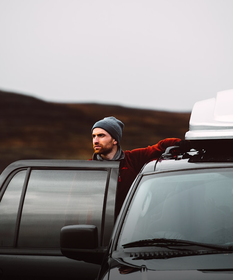 Man standing by an open car door, preparing to get in or out of the vehicle