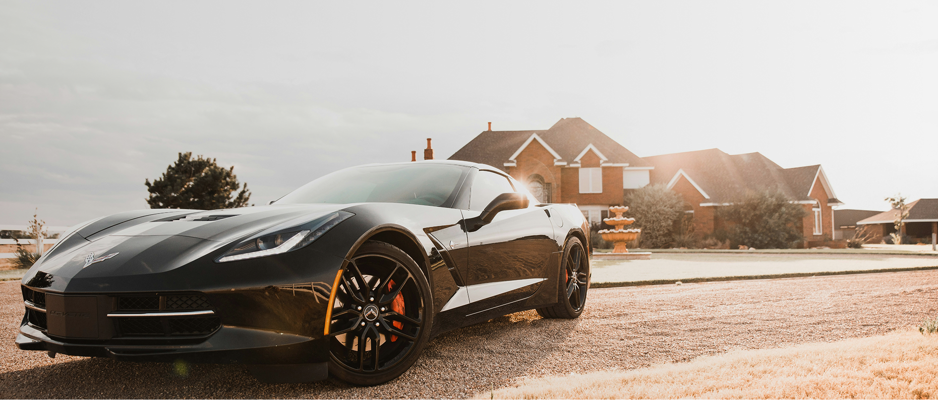 Luxury sports car parked in front of a modern house on a sunny day