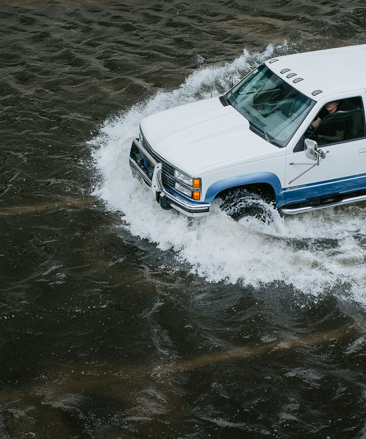 Vehicle driving through a flooded road during heavy rain